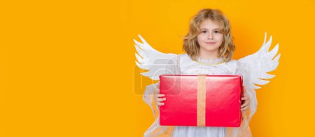Téléchargez les photos : Cute blonde kid angel with gift box present. Valentines day banner. Cute child with angel wings. Banner for header design, poster template - en image libre de droit