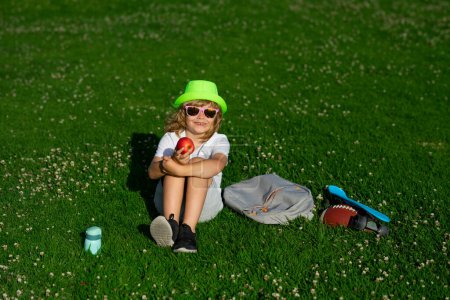 Foto de Id relaxing on green meadow. Happy kid boy enjoying on grass field and dreaming. Summer holiday - Imagen libre de derechos