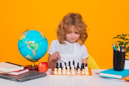 Photo for Child play chess on isolated background. Chess for intelligent kid. Child genius, smart pupil playing logic board game. Clever school boy thinking about chess - Royalty Free Image