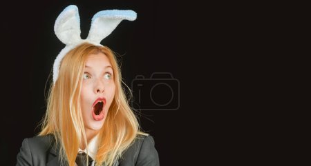 Téléchargez les photos : Bunny amazed surprised woman. Portrait of a excited woman in bunny ears. Easter bunny woman. Horizontal photo banner for website header design - en image libre de droit