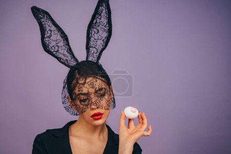 Téléchargez les photos : Femme de mode dans les oreilles de lapin avec oeuf de Pâques. Lèvres et Pâques, Empreinte baiser rouge à lèvres sur l'oeuf de Pâques - en image libre de droit