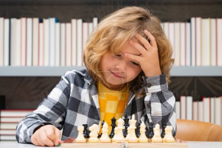Téléchargez les photos : Clever thinking child. Chess for intelligent kid. Child genius, smart pupil playing logic board game. Clever school boy thinking about chess - en image libre de droit