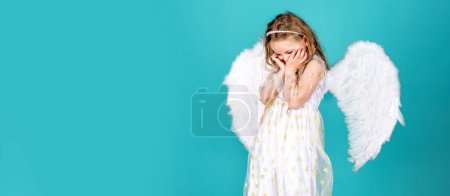 Foto de Angel child banner, isolated studio background. Face of beautiful little angel girl on color background. Pretty little angel girl. Child with angelic face - Imagen libre de derechos
