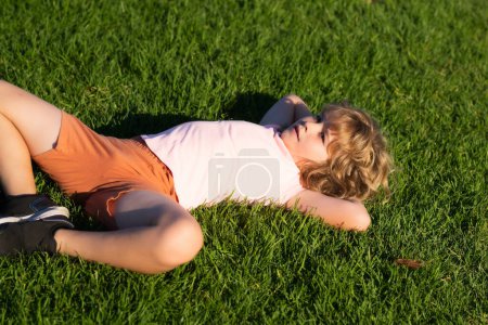 Foto de Happy childhood. Happy child enjoying on grass field and dreaming. Summer holiday - Imagen libre de derechos