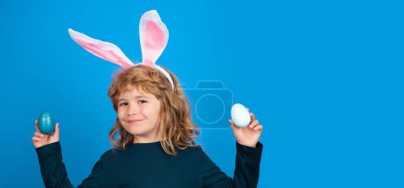 Téléchargez les photos : Bunny Easter child. Kid in rabbit bunny ears isolated on blue background. Funny kids face. Horizontal photo banner for website header design - en image libre de droit