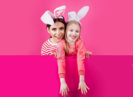 Téléchargez les photos : Bonne enfance. Des filles avec des oreilles de lapin. Les petites sœurs célèbrent Pâques. Chasse aux œufs. Vacances de printemps - en image libre de droit