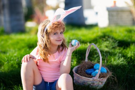 Foto de Conejito de Pascua niño con cara linda. Niños cazando huevos de Pascua. - Imagen libre de derechos