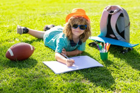 Foto de Child painter draw on playground. Child artist paints creativity vacation. Kid boy draws in park laying in grass having fun on nature background - Imagen libre de derechos