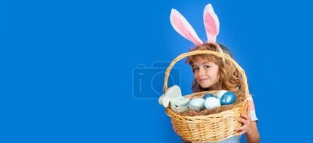 Téléchargez les photos : Happy Easter. Child boy with easter basket isolated on blue background. Funny kids face. Horizontal photo banner for website header design - en image libre de droit