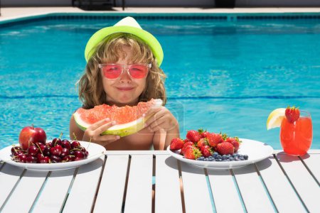 Photo for Summer fruit for children. Happy child playing in swimming pool. Portrait of summer kids. Summer kids vacation. Little kid boy relaxing in a pool having fun during summer vacation - Royalty Free Image