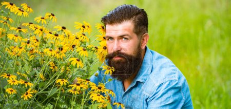 Téléchargez les photos : Carefree bearded man outdoor. Spring flowers. Unity with nature. Field and meadow - en image libre de droit