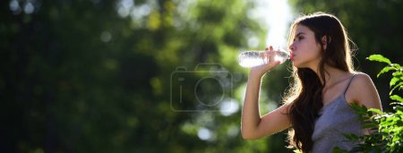 Téléchargez les photos : Healthy woman drinking water from bottle outdoor. Stay hydration concept. Unhidrated. Unity with nature, banner for website header. - en image libre de droit