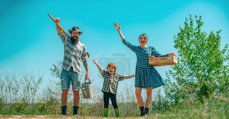 Photo for Farmers family of three in farm, spring banner. Eco farm. Family make small business: selling organic fruits and vegetables. Spring farming, springtime - Royalty Free Image