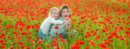 Téléchargez les photos : Beautiful mother and daughter in spring poppy flower field. Mom holds her child daughter in the flowering meadow piggyback ride. Mother and daughter on the poppies field background. Spring banner - en image libre de droit