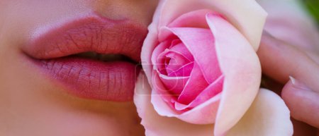 Foto de Lips and rose, close up spring banner. Natural paint from the lips. Sensual lips on beautiful model girls mouth. Beauty makeup close up. Spring flowes - Imagen libre de derechos