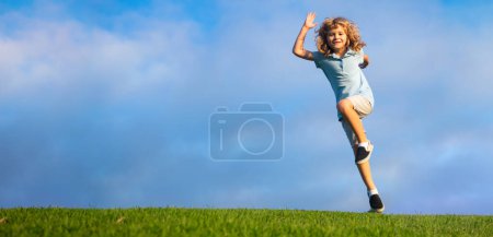 Photo for Little adorable boy running on grass. Excited kid play the green grass. The child has blond long hair and a t-shit. Spring and kid. Wide photo banner for website header - Royalty Free Image