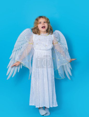 Téléchargez les photos : Valentines day. Blonde cute child with angel wings on a blue isolated studio background. Happy angel child - en image libre de droit