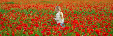 Téléchargez les photos : Little girl on the poppies meadow. Spring and kid. Wide photo banner for website header. Beautiful daughter on a poppy field outdoor. Spring flower blossom meadow background - en image libre de droit