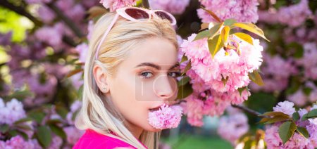 Photo for Sensual woman near sakura tree background, banner for website header. Beautiful girl in pink flowers in summer blossom park. Portrait of young woman in the flowered garden in the spring - Royalty Free Image