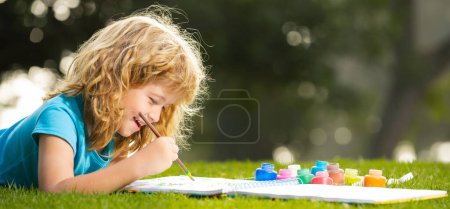 Photo for Portrait of smiling happy kid enjoying art and craft drawing in backyard or spring park. Happy child playing outside. Drawing summer theme. Spring and kid. Banner for website header - Royalty Free Image