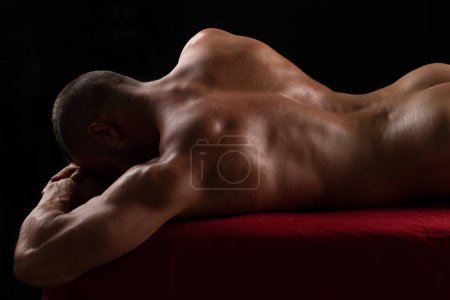 Téléchargez les photos : Gay lgbt concept. Sexy male back. Strong handsome athletic male model on black studio background. Perfect butt, buttocks and shoulders - en image libre de droit