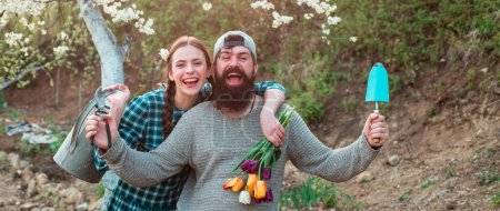 Photo for Couple of young farmers in farm, spring banner. Spring couple in love on garden. Loving people in blooming spring garden. Happy couple gardening together outdoor - Royalty Free Image