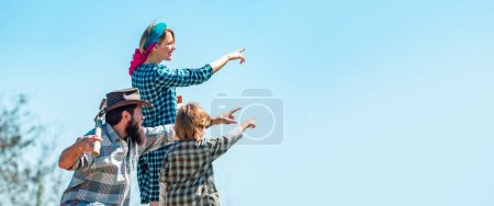 Photo for Farmers family of three in farm, spring banner. Family showing up on farm. Life for family farmers in the countryside - Royalty Free Image