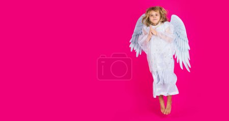 Téléchargez les photos : Little angel jump, kids jumping, full body. Little angel fly. Cute angel kid, studio portrait. Blonde curly little angel child with angels wings, isolated background. Banner header, copy space - en image libre de droit