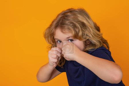 Photo for Boy fight, battle. Angry child with fist gesture fight, hit on studio isolated background. Kid boy with mad expression handed punch. Bad kids behavior. Fury boy - Royalty Free Image