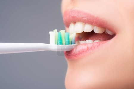 Téléchargez les photos : Close-up mouth with teeth-brush. Closeup on happy young woman brushing teeth. Dental concept - en image libre de droit