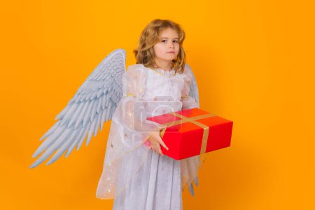 Photo for Angel child hold gift present. Kid wearing angel costume white dress and feather wings. Innocent child - Royalty Free Image