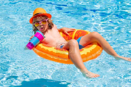 Foto de Niño en piscina en anillo inflable. Los niños nadan con flotador naranja. Juguete acuático, actividad deportiva al aire libre saludable para niños. Niños playa diversión - Imagen libre de derechos