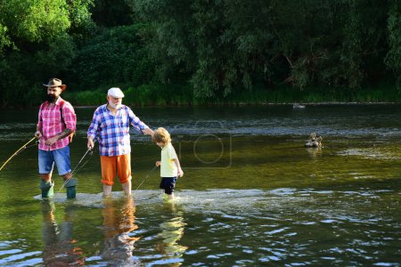 Téléchargez les photos : I love fishing. Happy people family have fishing and fun together. Grandfather, father and son are fly fishing on river - en image libre de droit