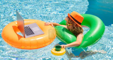 Photo for Business and summer. Child working on laptop in summer pool. Little freelancer using computer, remote working in poolside - Royalty Free Image