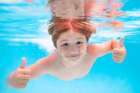 Photo for Child face underwater with thumbs up. Child swimming underwater in swimming pool. Funny kids boy play and swim in the sea water - Royalty Free Image
