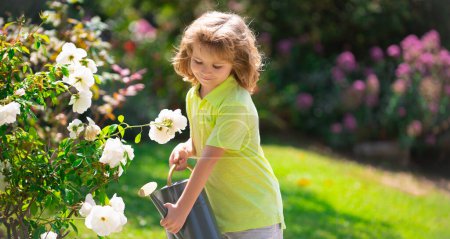 Photo for Kid with watering can, spring banner. Child pouring water on the trees. Kid helps to care for the plants in the garden. Little boy with a watering can on backyard - Royalty Free Image