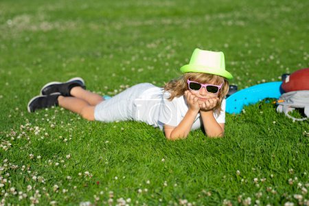Photo for Kids playing outdoors in spring park. Freedom and carefree. Happy childhood. Relaxing kid in green field on grass during spring. Healthy lifestyle concept - Royalty Free Image