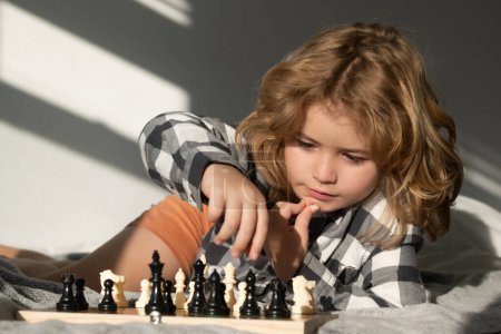 Photo for Chess game with kids at home. Chess for intelligent kid. Child genius, smart pupil playing logic board game. Clever school boy thinking about chess - Royalty Free Image