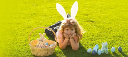 Téléchargez les photos : Easter banner, mockup copy space, poster flyer header for website template. Child boy with easter eggs and bunny ears outdoor. Cute kid having happy easter in park. Happy Easter - en image libre de droit
