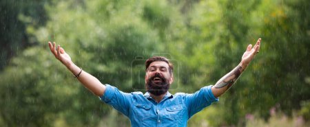 Foto de Man on spring rain, banner. Autumn rainy weather concept. Waterproof wear. Happy man under rain - Imagen libre de derechos