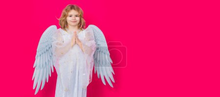 Angel prayer kids. Valentines day. Blonde cute child with angel wings on a yellow studio background. Banner for website header design
