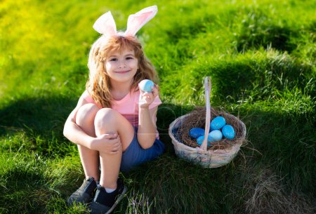 Téléchargez les photos : Joyeux Pâques. Enfants dans les oreilles de lapin avec oeuf de Pâques dans le panier. Garçon jouer dans la chasse oeufs. - en image libre de droit