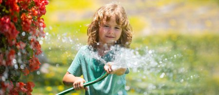Foto de Spring child watering, banner. Funny little boy playing with garden hose in backyard. Child having fun with spray of water on yard nature background. Summer kids outdoors activity - Imagen libre de derechos