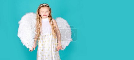 Téléchargez les photos : Angel kid banner, isolated studio background. Looks like an angel. Face of beautiful little angel girl on color background - en image libre de droit