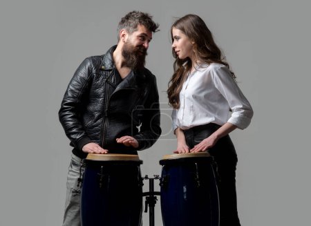 Téléchargez les photos : Drums conga music. Excited couple hitting on conga drums isolated on gray background - en image libre de droit