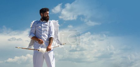 Photo for Funny cupid, handsome guy on valentine day with bow arrow shooting. Love concept. Handsome crazy fun angel. Horizontal photo banner for website header - Royalty Free Image