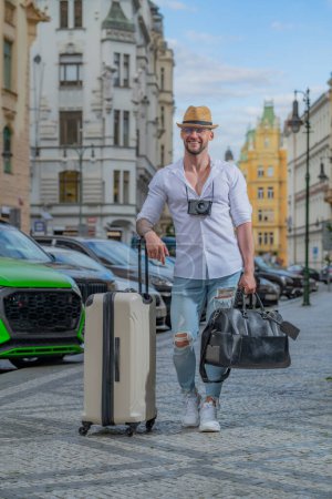 Foto de Travelling concept. Business man on business trip walking with travel bag on city street. Travelling businessman - Imagen libre de derechos