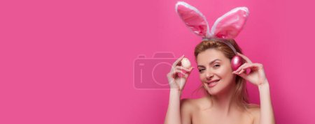 Foto de Smiling bunny girl. Happy easter. Pinup style isolated on pink banner, copy space. Panoramic web banner frame - Imagen libre de derechos