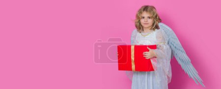 Photo for Cute kid angel with gift box present. Beautiful little angel. Isolated studio shot. Cute Pretty child with angel wings. Banner header with copy space - Royalty Free Image