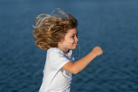 Foto de Happy childhood. Kid boy running outdoor. Sport for children. Runner kids race in park - Imagen libre de derechos